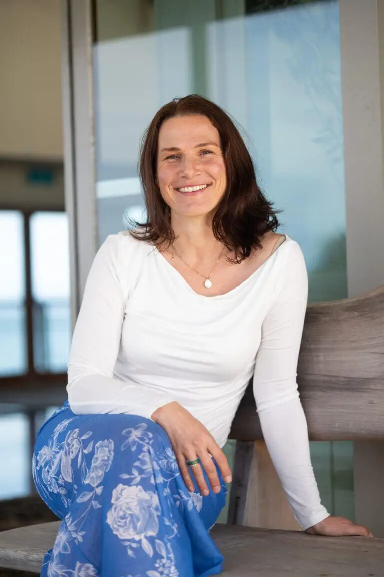 Tarisha Tourok sitting and smiling in a white top