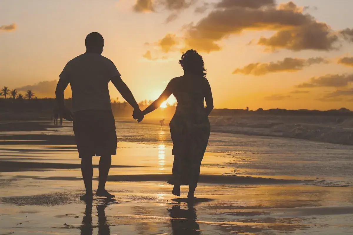 Couple standing on body of water during golden hour