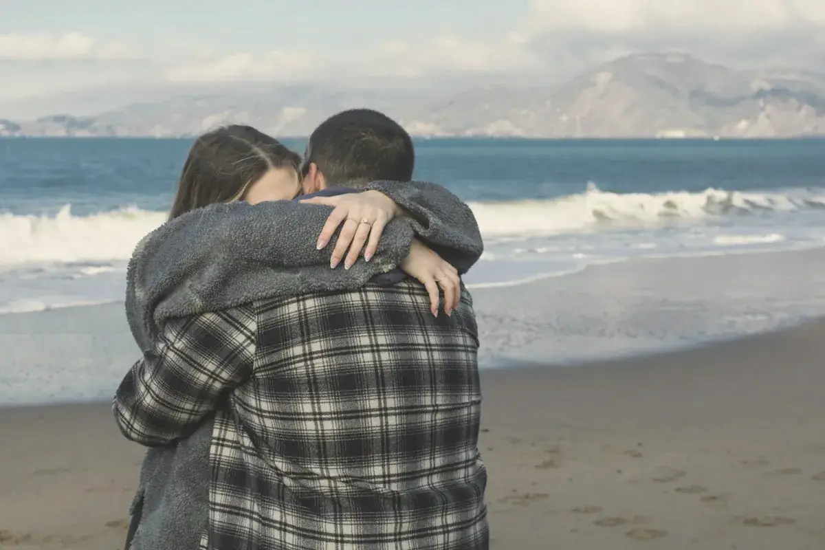 A man and a woman hugging on the beach