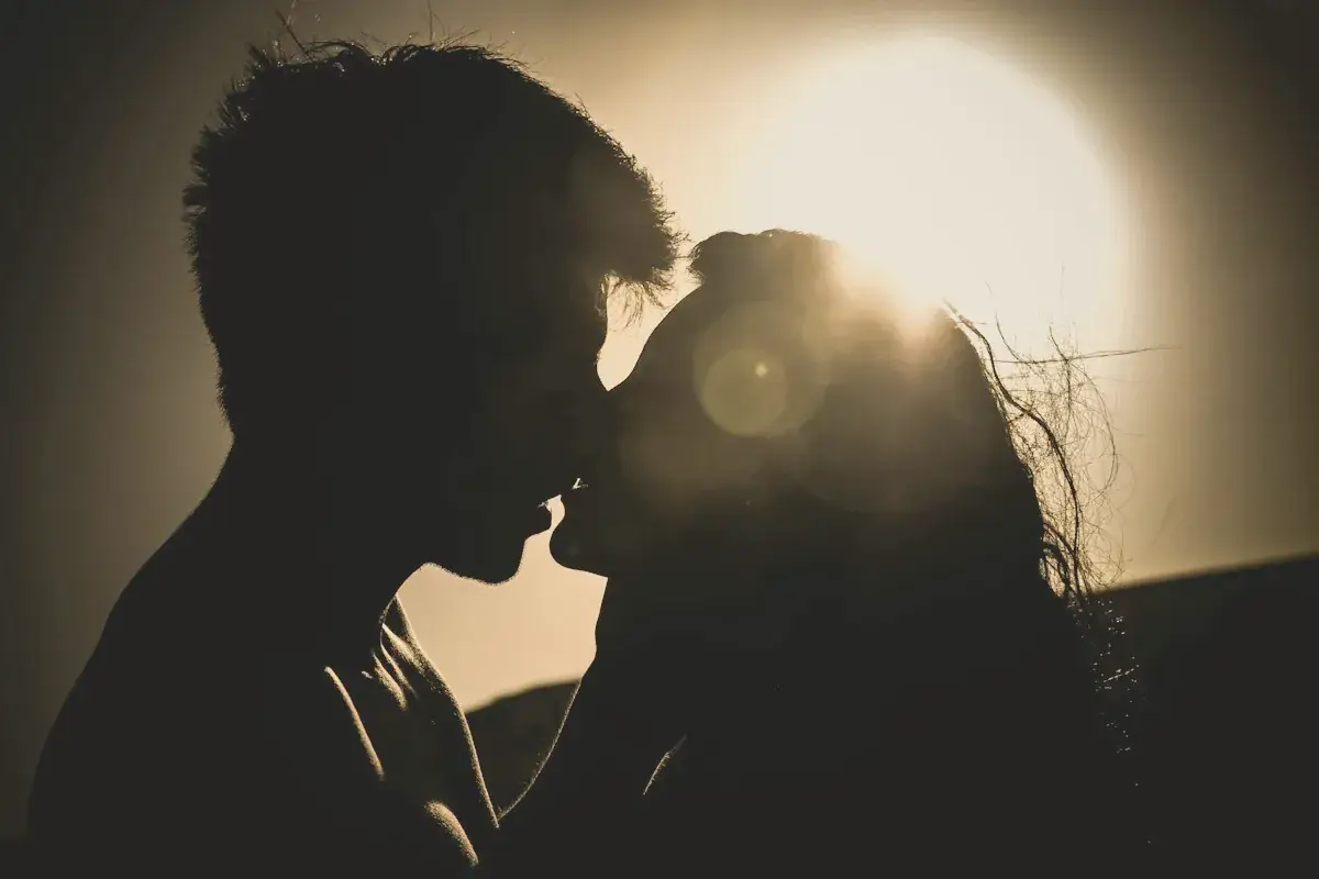 Man and woman kissing under the sun