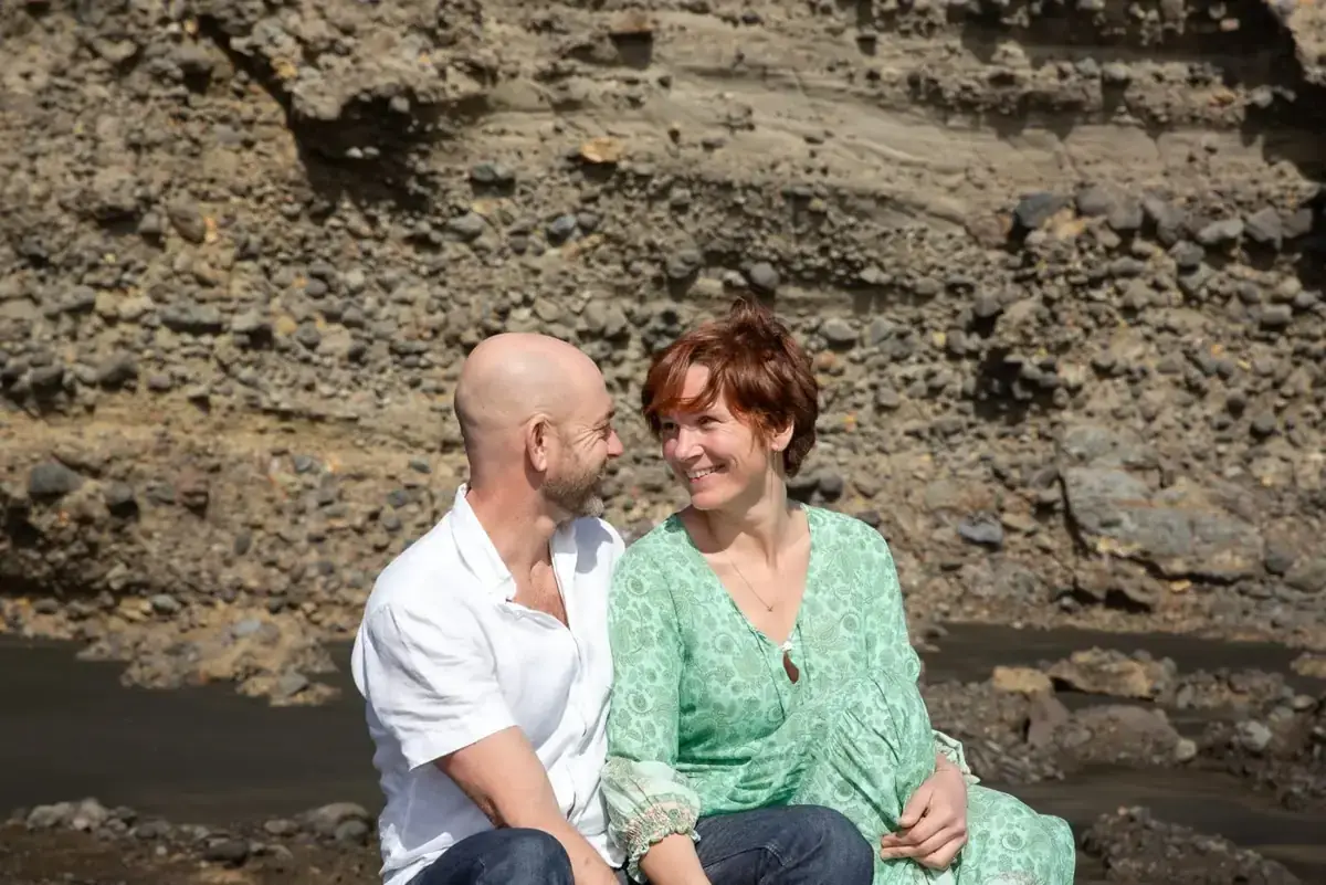 Tarisha and Mark sitting together on the rocks, talking