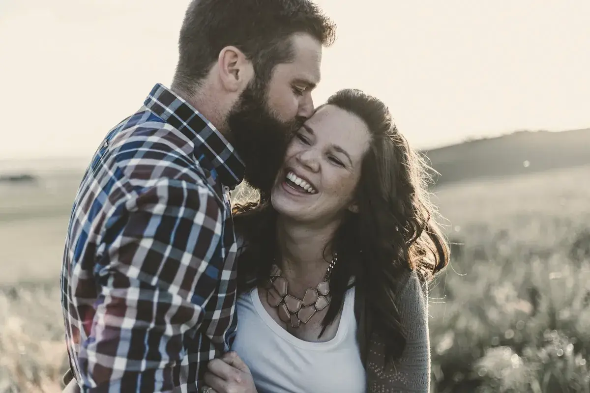 Man kissing woman in grass area