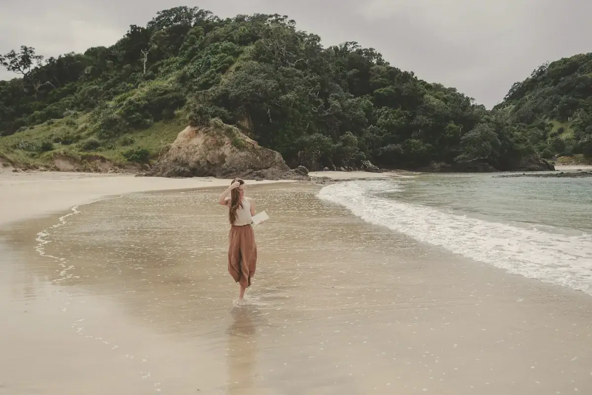 A woman standing on top of a sandy beach