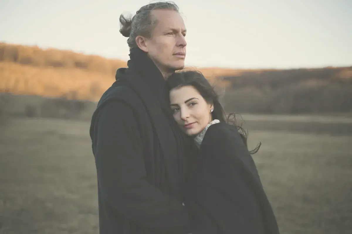 A man and a woman standing in a field