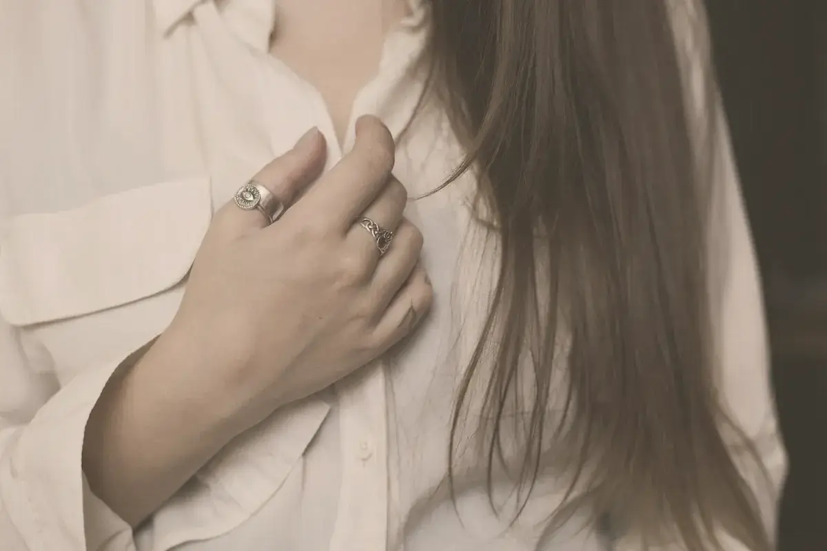A woman wearing a white shirt and a silver ring