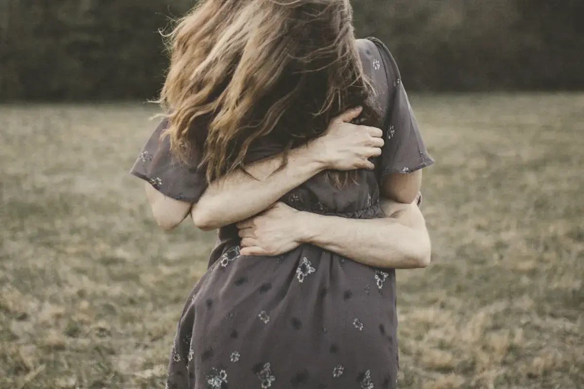 A woman standing in a field with her hair blowing in the wind