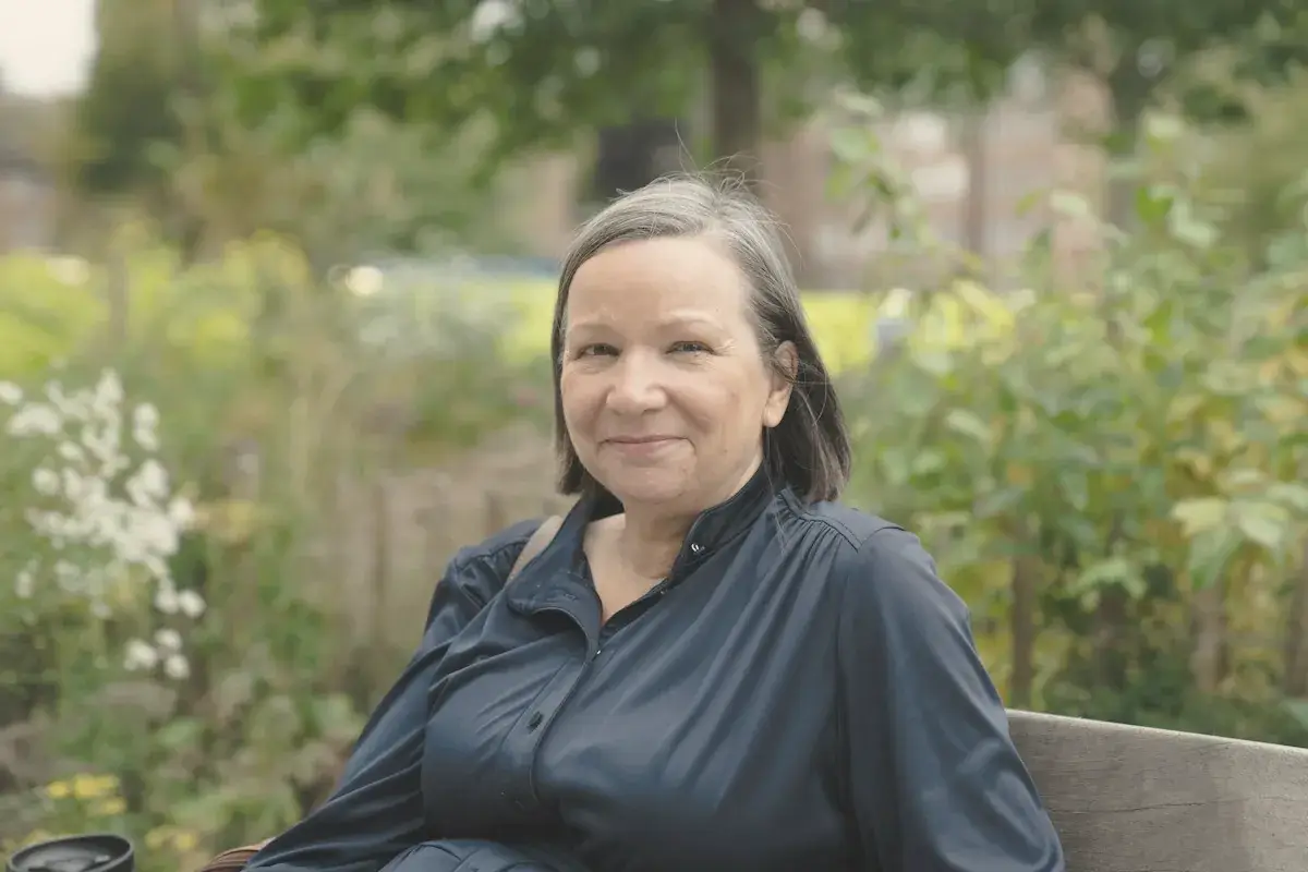 A woman smiles in a park setting
