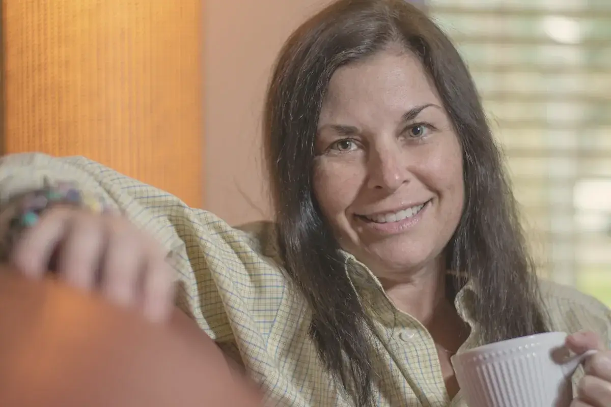 Woman in white and black plaid button up shirt smiling