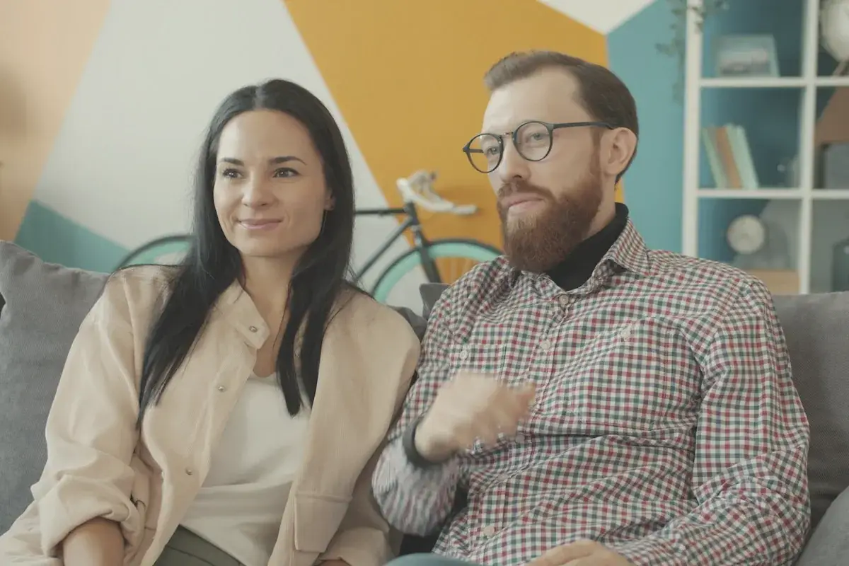 Couple sitting on a couch watching something