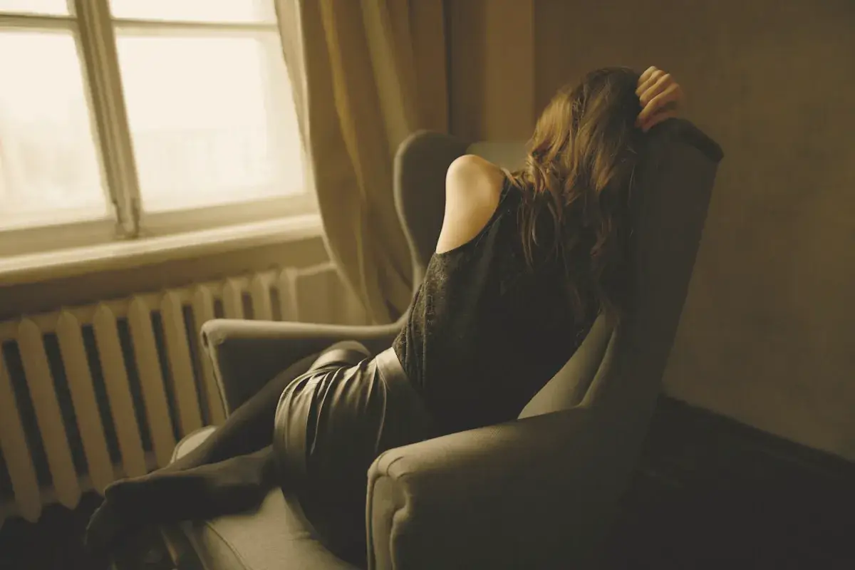 Woman sitting on wing chair