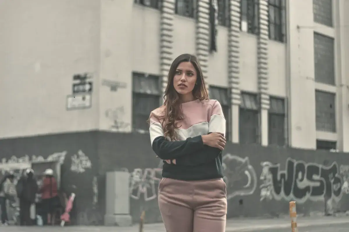 Woman standing beside black and gray concrete building